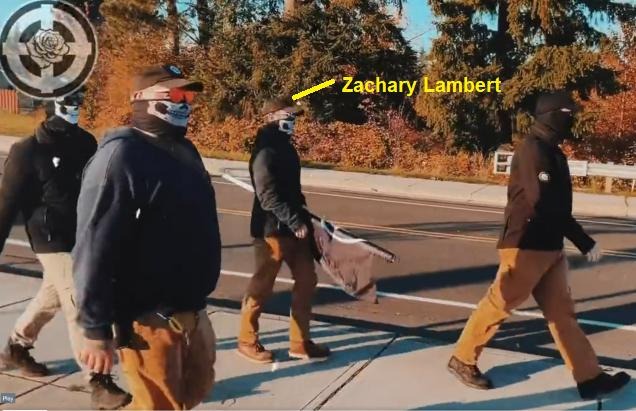 Neo-Nazi group Rose City Nationalists walking down a sidewalk wearing skull masks. Zachary Lambert is labelled.