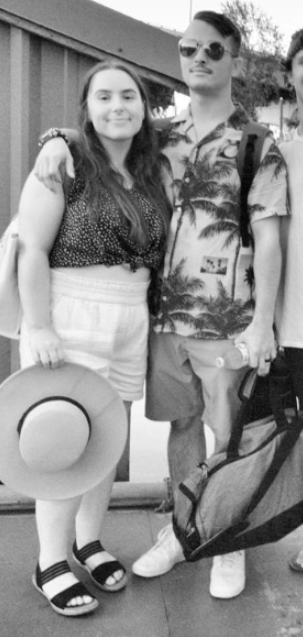 A black and white photo of Neo-Nazi Zachary Lambert and his wife Alyssa. They are at some 4th of July event, wearing summery clothes and Zach is holding a duffel bag.