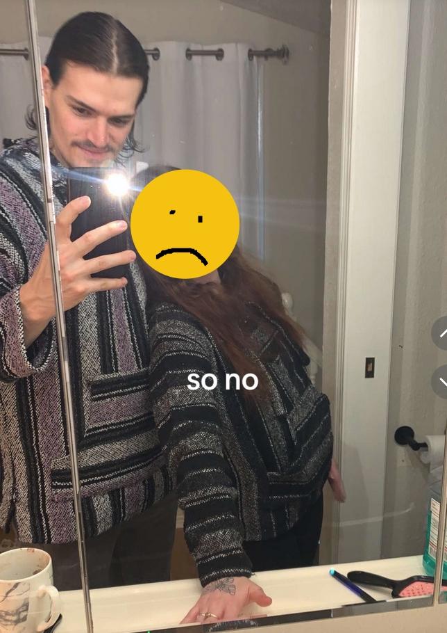 Micah Calabrese, bathroom mirror selfie with his girlfriend. Her face is blurred. They are both wearing Baja hoodies.